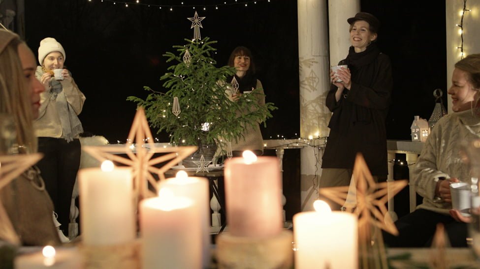 5 naista laulaa joulutervehdyksen jouluisella terassilla